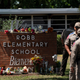 Flowers and candles are placed outside Robb Elementary School in Uvalde, Texas, Wednesday, May 25, 2022, to honor the victims killed in Tuesday’s shooting at the school. Desperation turned to heart-wrenching sorrow for families of grade schoolers killed after an 18-year-old gunman barricaded himself in their Texas classroom and began shooting, killing several fourth-graders and their teachers.